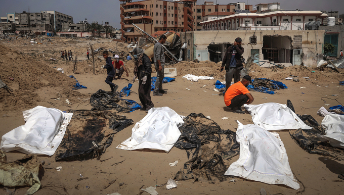 Người dân và nhân viên y tế khai quật các thi thể được chôn tại bệnh viện Nasser, thành phố Khan Younis, phía nam Dải Gaza ngày 23/4. Ảnh: AFP