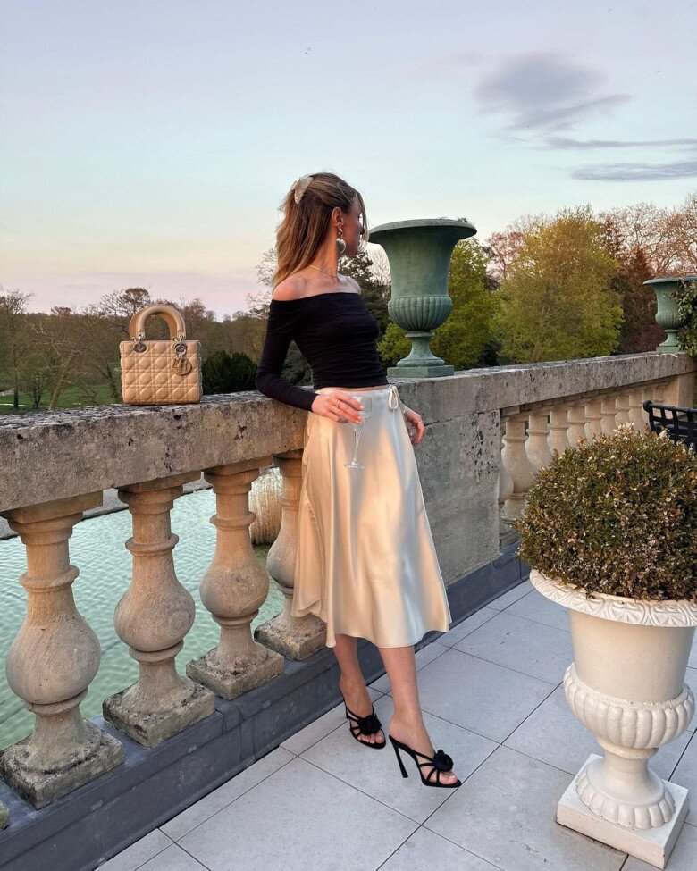 Áo trễ vai ôm sát và chân váy lụa midi màu champagne mang đến vẻ sang trọng, quyến rũ.