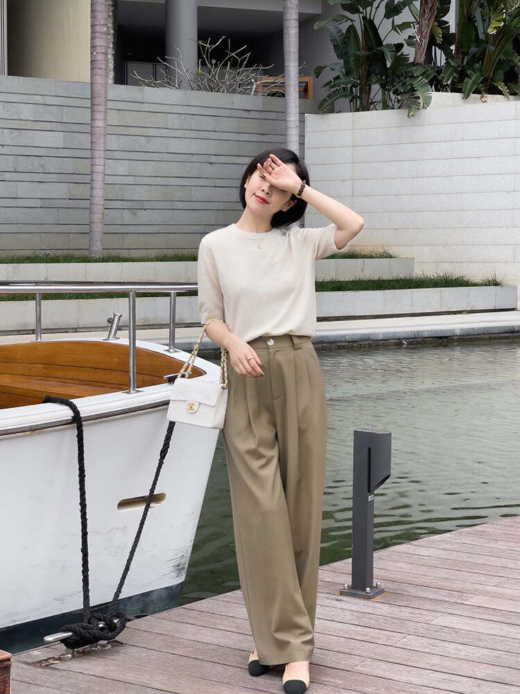 Sự kết hợp giữa áo knit màu be nhẹ nhàng và quần ống đứng màu olive tạo nên hình ảnh một quý cô thành thị tự do, thời thượng, vừa đủ mềm mại cho những ngày dạo phố ven sông.