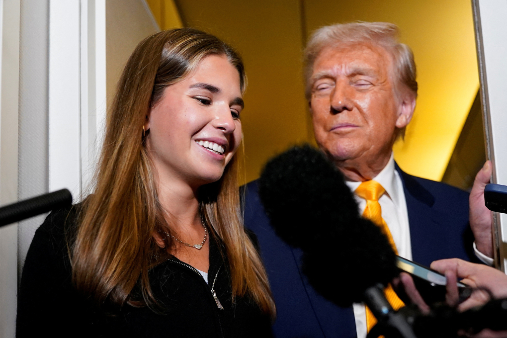 Kai Trump trả lời báo giới cùng ông nội trên chuyên cơ Không lực Một, rạng sáng 13/4. Ảnh: Reuters