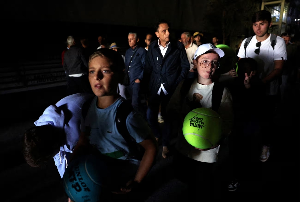 Khán giả rời sân vận động tennis tại Madrid vì mất điện vào trưa 28/4. Ảnh: Reuters