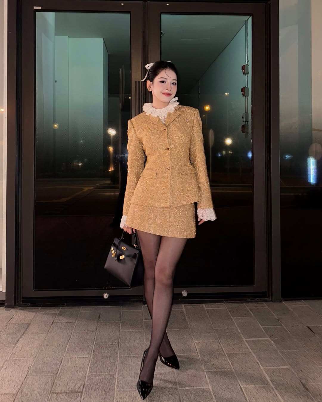 Tham gia tiệc tối, mỹ nhân đẹp nhất Việt Nam chọn set đồ mang hơi hướng cổ điển với áo và chân váy vải tweed, điểm xuyết chi tiết cổ áo bèo nhún trắng tinh tế.