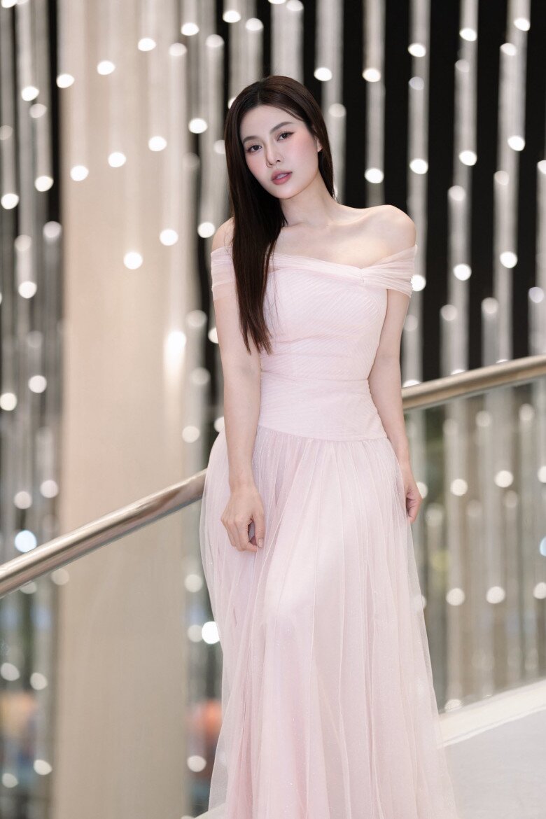 Chiếc váy voan hồng phấn dáng dài, trễ vai mềm mại mang đến vẻ đẹp mong manh, nữ tính cho Thanh Hương. Phom dáng bay bổng kết hợp chất liệu xuyên nhẹ giúp tổng thể thêm phần thanh thoát.