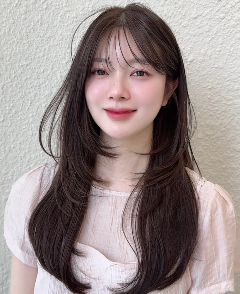 Tóc dài layer đuôi cụp mang lại vẻ ngoài mềm mại, nữ tính nhưng vẫn hiện đại. Các lớp tóc giúp tạo độ bồng bềnh, kết hợp phần đuôi cụp giúp gương mặt thanh thoát, đồng thời giữ được độ dài tóc mà không gây cảm giác nặng nề.