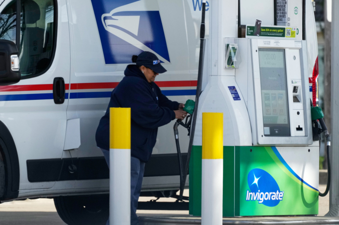 Nhân viên cơ quan Dịch vụ Bưu chính Mỹ (USPS) đổ xăng tại một trạm bơm ở Chicago ngày 7/4. Ảnh: AP