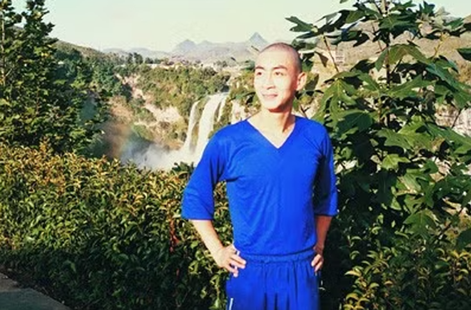 Lục Tiểu Linh Đồng chụp ảnh kỷ niệm với hậu cảnh là thác nước Hoa Quả Sơn ở Quý Châu.