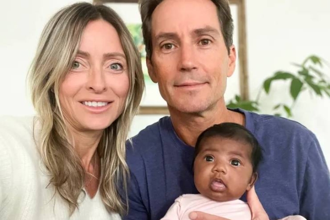 Cặp vợ chồng Mỹ bên con gái da màu sau khi người vợ bị chuyển nhầm phôi. Ảnh: Steven Mills