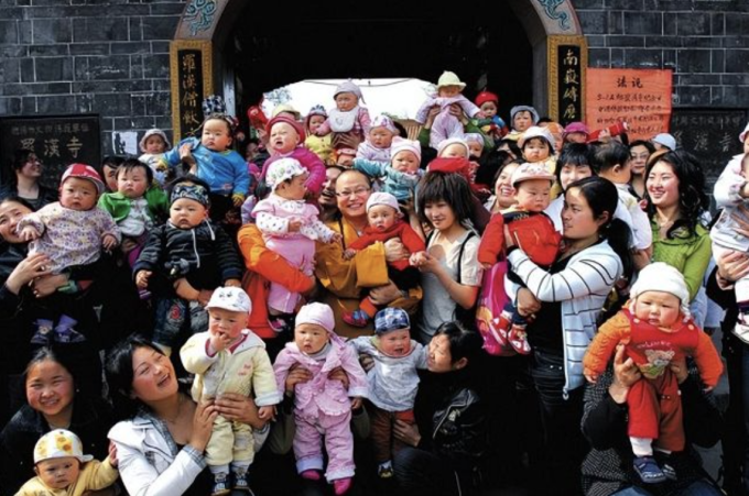 Năm 2010, sư thầy Suquan chụp ảnh cùng 108 đứa trẻ được sinh ra tại chùa La Hán, tỉnh Tứ Xuyên sau trận động đất năm 2008. Ảnh: 163.com