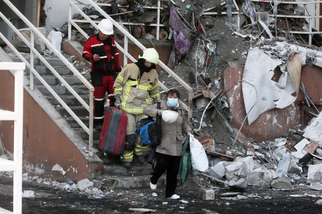 Nhân viên cứu hộ hỗ trợ người dân địa phương rời khỏi một tòa nhà trúng tên lửa ở Odessa, Ukraine ngày 24/4. Ảnh: AFP.