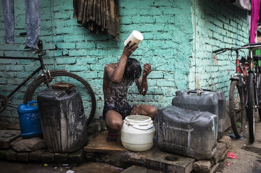 Cậu bé dội nước lên người trong ngày hè nóng nực ở New Delhi, Ấn Độ, hôm 3/5. Ảnh: AFP.