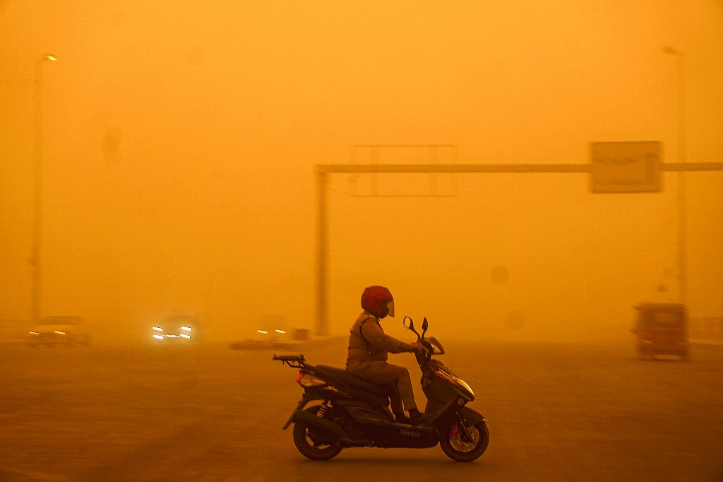 Một người lái xe máy khi cơn bão cát tấn công thủ đô Baghdad sáng sớm 16/5. Ảnh: AFP