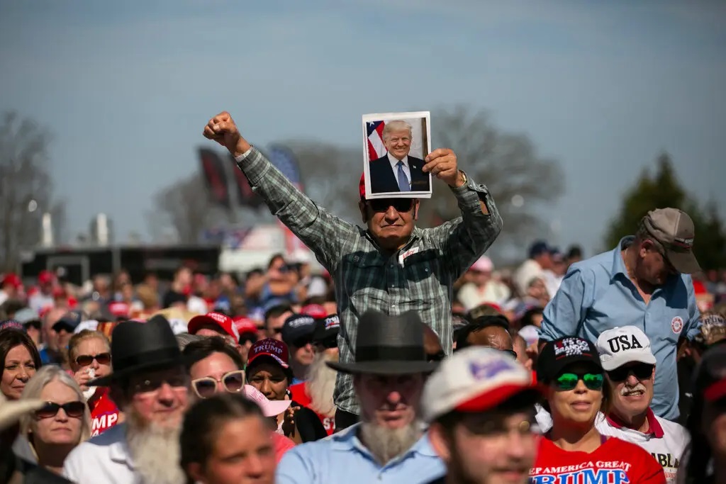 Người ủng hộ cầm ảnh cựu tổng thống Donald Trump tại một cuộc vận động tranh cử ở Delaware, Ohio tháng trước. Ảnh: NY Times.