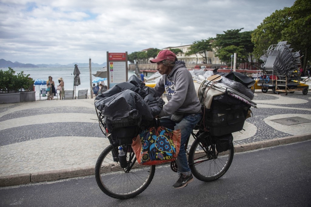 Một người đàn ông mặc áo rét đạp xe dọc con đường quanh bãi biển Copacabana ở Rio de Janeiro, Brazil, ngày 19/5. Ảnh: AFP