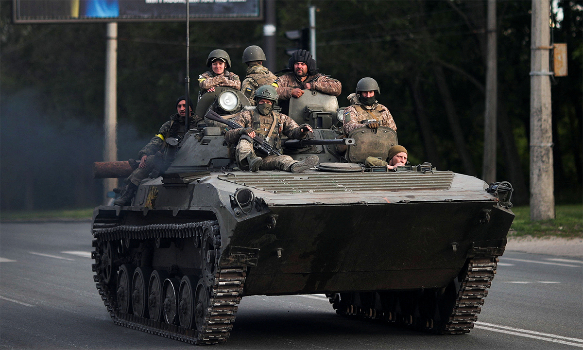 Binh sĩ Ukraine ngồi trên thiết giáp đi trên tuyến đường ở tỉnh Kharkov ngày 16/5. Ảnh: Reuters.