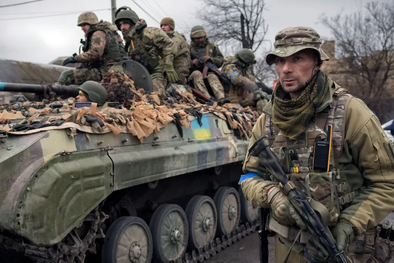Binh sĩ Ukraine cạnh một xe thiết giáp ở ngoại ô Kiev. Ảnh: AP