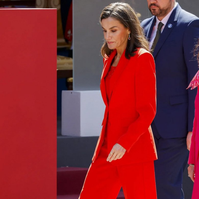 Tại sự kiện, nữ hoàng Letizia xuất hiện đầy khí chất và cuốn hút trong bộ suit đỏ vô cùng nổi bật. Tuy nhiên điều gây chú ý hơn cả không phải ở màu sắc nổi bật của bộ đồ mà chính là đôi giày bệt màu trắng được nữ hoàng mix amp; match cùng set đồ mà không phải một đôi cao gót như thường thấy.
