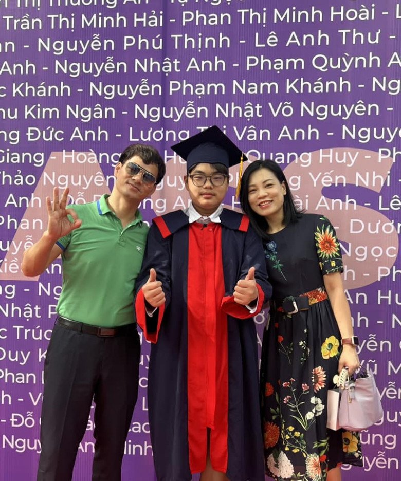 Gia đình Xuân Bắc cùng nhau chụp ảnh trước bảng tên của các học sinh tốt nghiệp, có tên thật của Bi - Nguyễn Nhật Võ Nguyên.