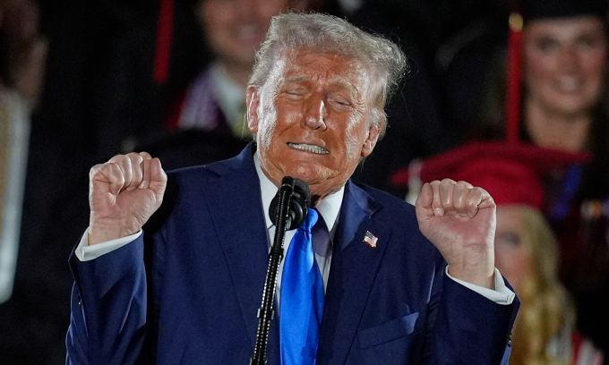 Ông Trump bắt chước động tác của vận động viên cử tạ khi phát biểu tại đại học Alabama hôm 1/5. Ảnh: AP