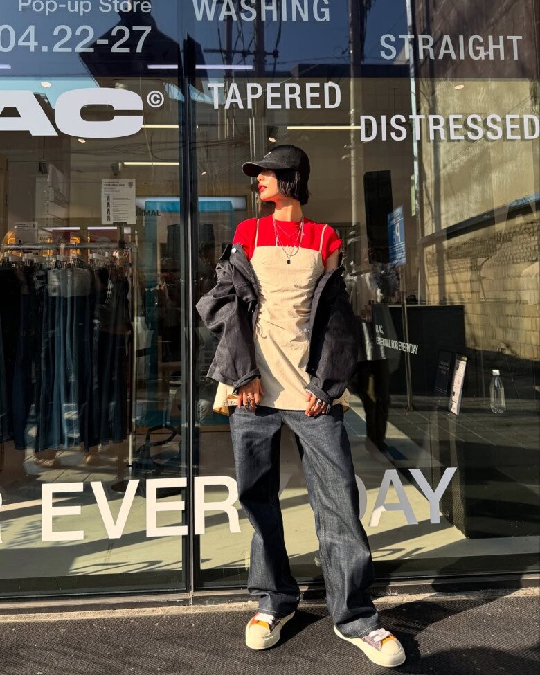 Nana cũng không ngần ngại kết hợp những item tưởng như chẳng liên quan - áo thun đỏ trơn và váy mini kết hợp quần jeans ống rộng - tạo ra một bộ phối phá cách với những màu sắc tương phản thú vị