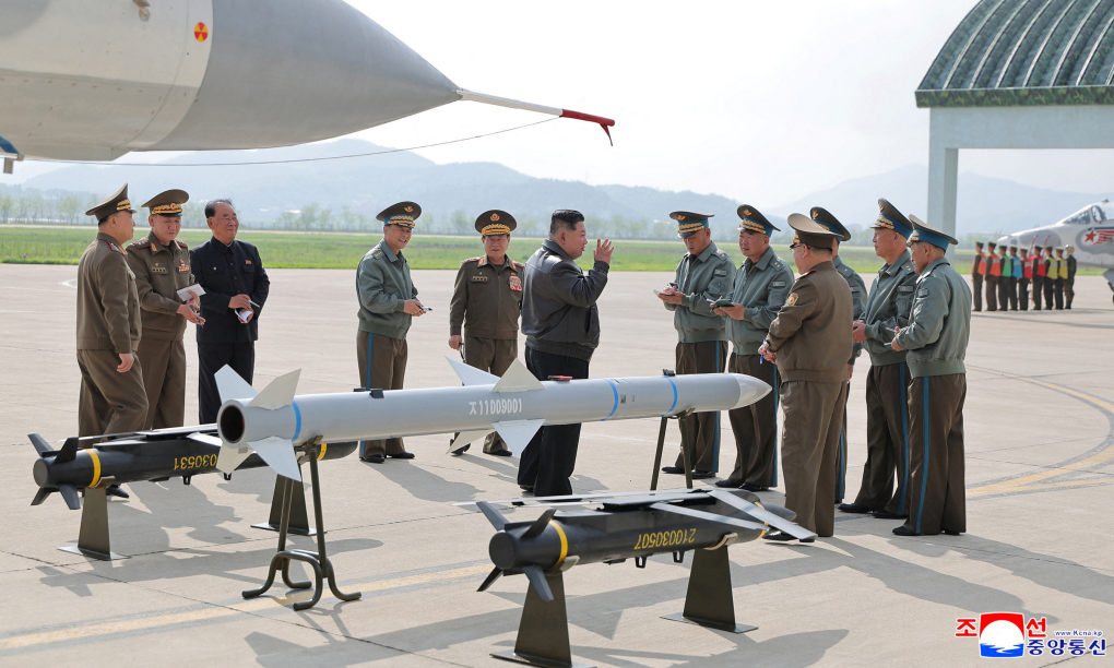 Ông Kim Jong-un bên cạnh mẫu tên lửa, bom mới trong ảnh công bố hôm nay. Ảnh: KCNA