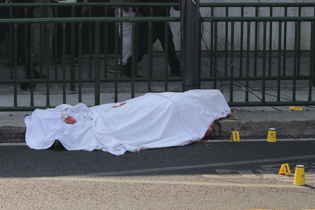 Thi thể tại hiện trường vụ ám sát thư ký và cố vấn của Thị trưởng Mexico City sáng 20/5. Ảnh: AP