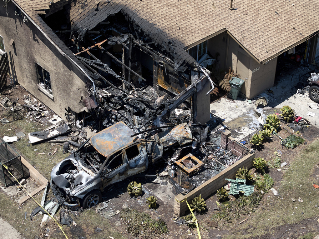 Chiếc xe và ngôi nhà bị phá hủy sau khi máy bay lao xuống khu dân cư ở thành phố San Diego, bang California rạng sáng ngày 22/5. Ảnh: AP