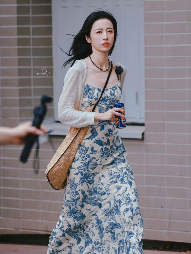 Chiếc váy maxi hoa xanh trắng cùng áo khoác mỏng và túi cói tạo nên vẻ đẹp phóng khoáng, nữ tính đậm chất thơ.