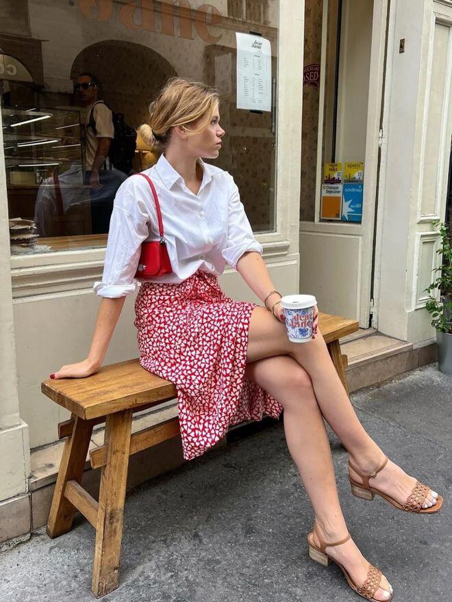 Sơ mi trắng phối chân váy đỏ họa tiết tim mang phong cách Parisian chic: vừa cổ điển, vừa lãng mạn.