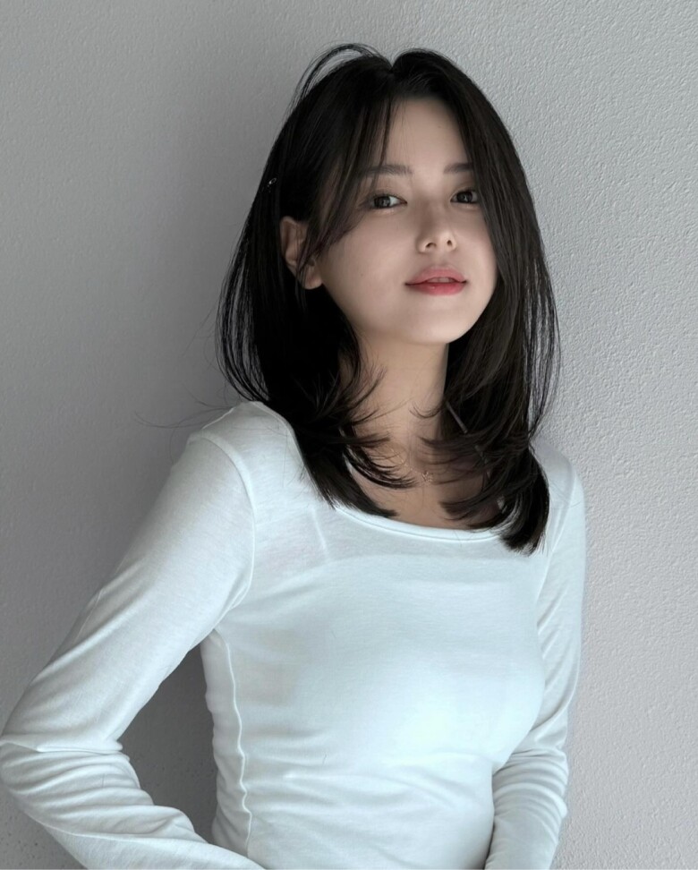 Kiểu tóc ngang vai rẽ ngôi lệch mang lại cảm giác hiện đại và thanh thoát cho gương mặt. Phần tóc chia lệch giúp tổng thể trông thon gọn hơn, đồng thời tạo hiệu ứng trưởng thành nhưng không bị già. Đây là lựa chọn được nhiều chị em công sở yêu thích.