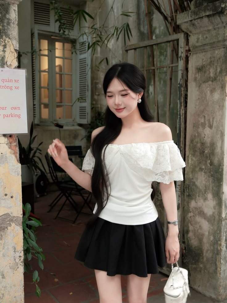 Áo trễ vai kết hợp với chân váy ngắn giúp outfit trở nên trẻ trung và hack tuổi rõ rệt. Thiết kế hở vai tạo cảm giác mềm mại, trong khi chân váy ngắn giúp tổng thể năng động hơn. Đây là công thức phù hợp cho những buổi đi chơi mùa Hè.