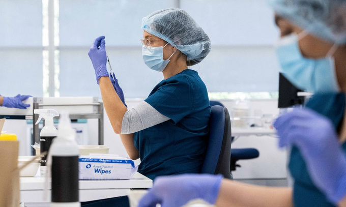 Nhân viên y tế chuẩn bị mũi tiêm vaccine Covid-19 tại điểm tiêm chủng ở Sydney đầu tháng 5. Ảnh: Reuters.