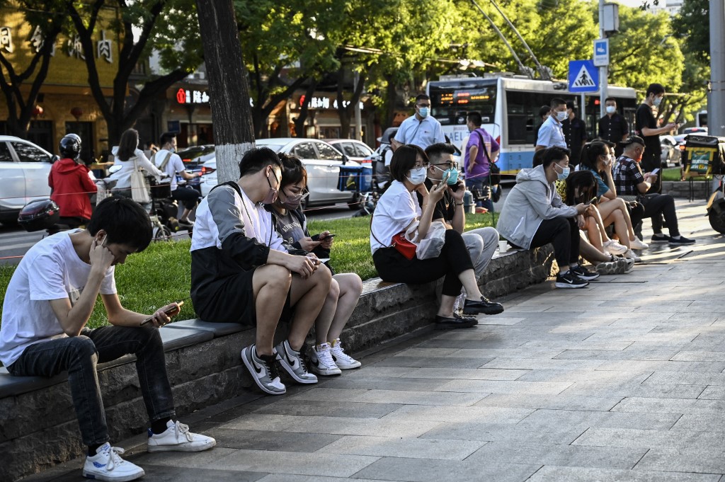 Người dân ngồi chờ tới lượt trước một nhà hàng ở Bắc Kinh ngày 6/6. Ảnh: AFP