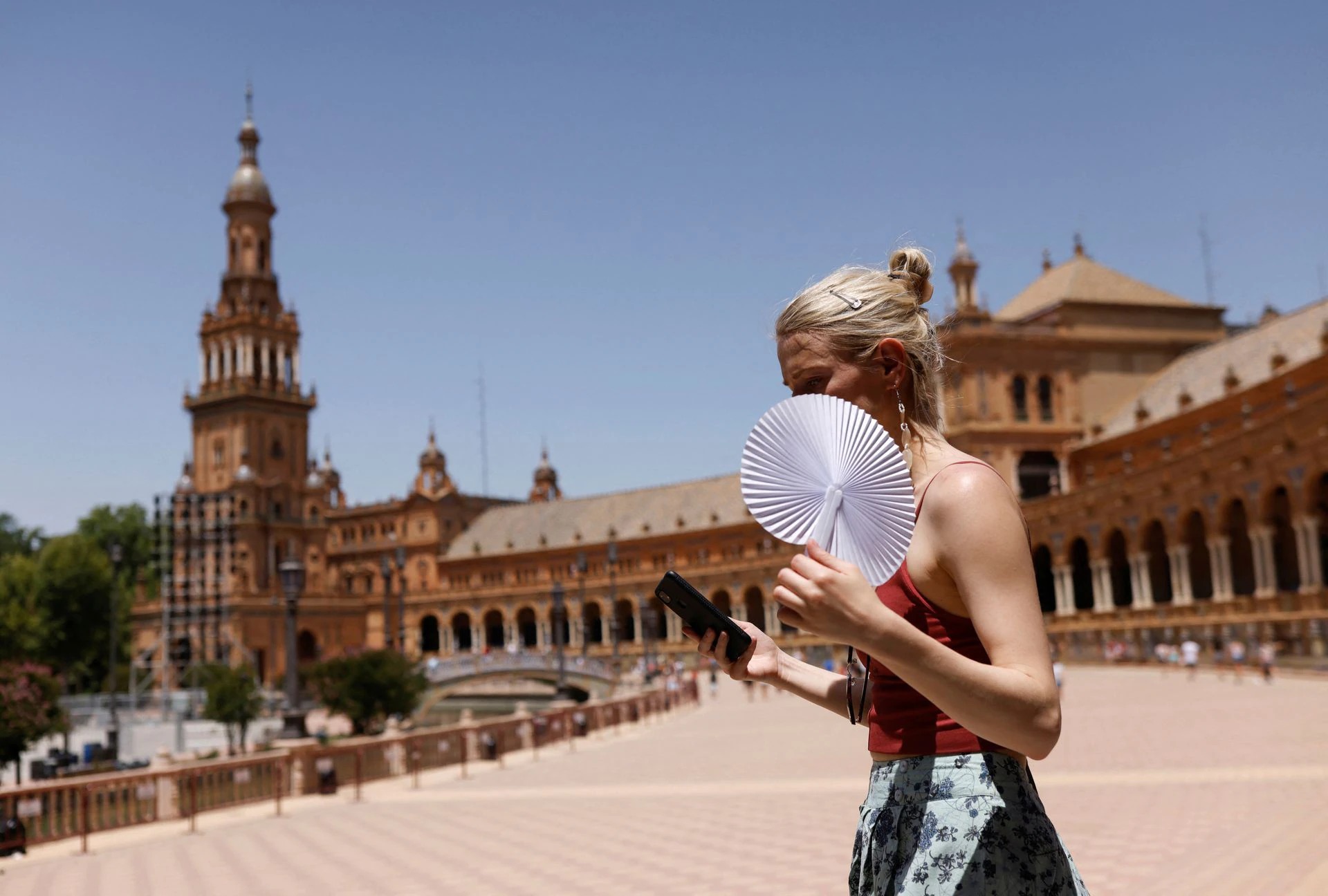 Một phụ nữ lấy quạt che nắng ở Seville, Tây Ban Nha, ngày 11/6. Ảnh: Reuters