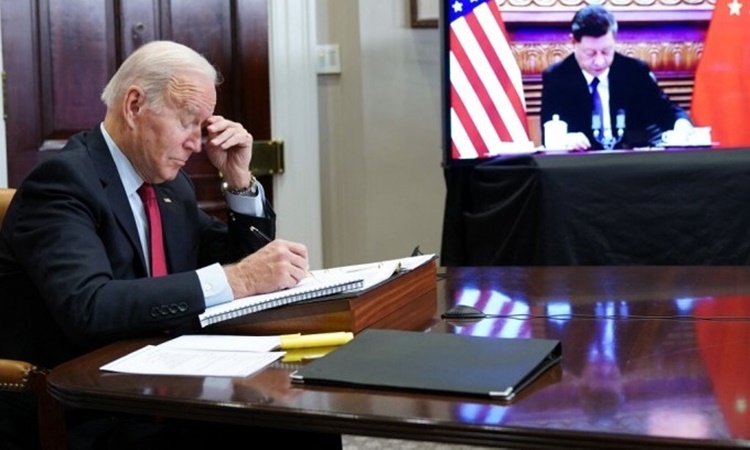 Tổng thống Mỹ Joe Biden và Chủ tịch Trung Quốc Tập Cận Bình (trên màn hình) họp thượng đỉnh trực tuyến hôm 16/11. Ảnh: AFP.