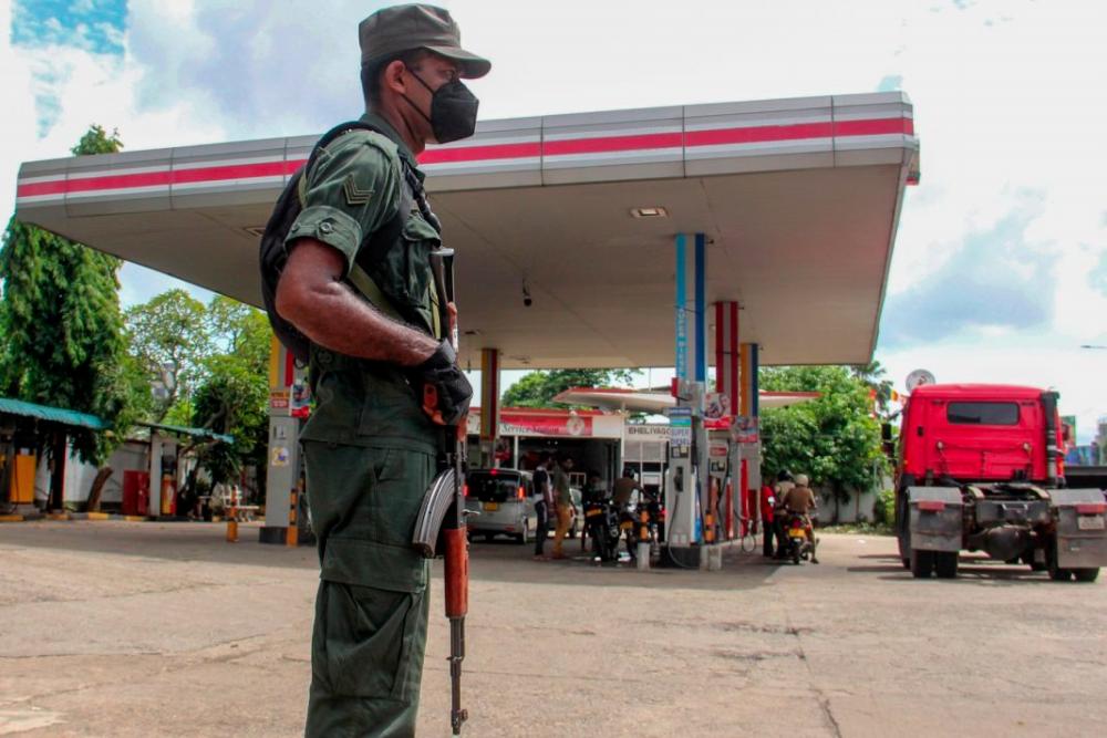 Nhân viên an ninh Sri Lanka cầm súng đứng gác trước một trạm xăng ở thủ đô Colombo hôm 19/6. Ảnh: AFP.