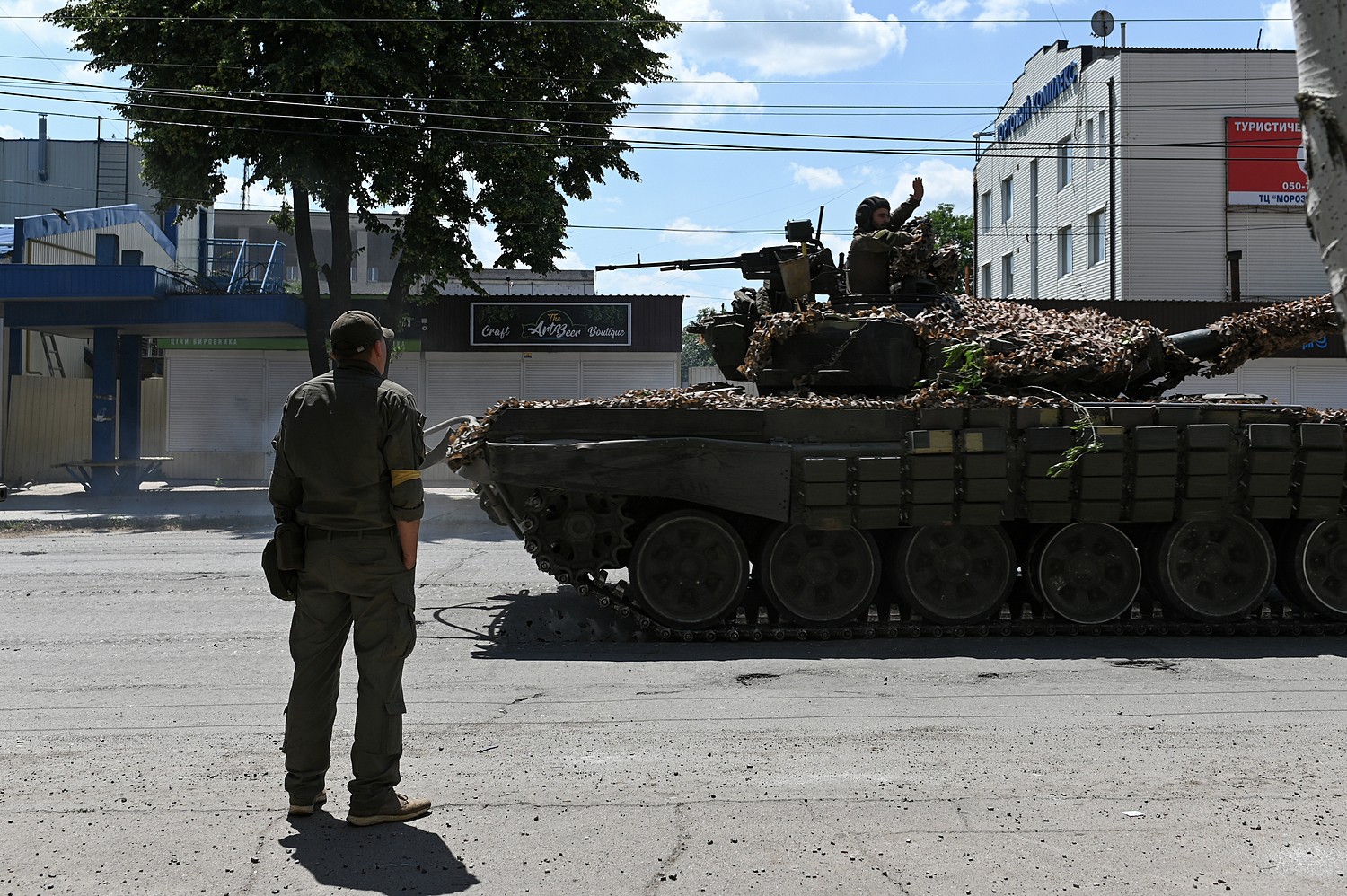 Binh sĩ Ukraine quan sát xe tăng của quân đội nước này di chuyển trên đường phố Lysychansk ngày 19/6. Ảnh: Reuters.