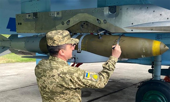 Lính Ukraine viết chữ lên bom lượn JDAM-ER gắn trên tiêm kích Su-27 tháng 11/2023. Ảnh: BQP Ukraine