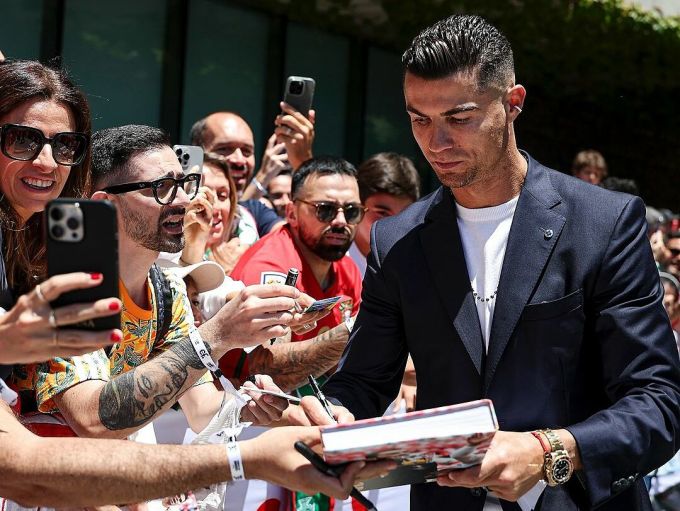 Ronaldo ký tặng fan trước giờ khởi hành đến Đức. Ảnh: Portugal Sports team
