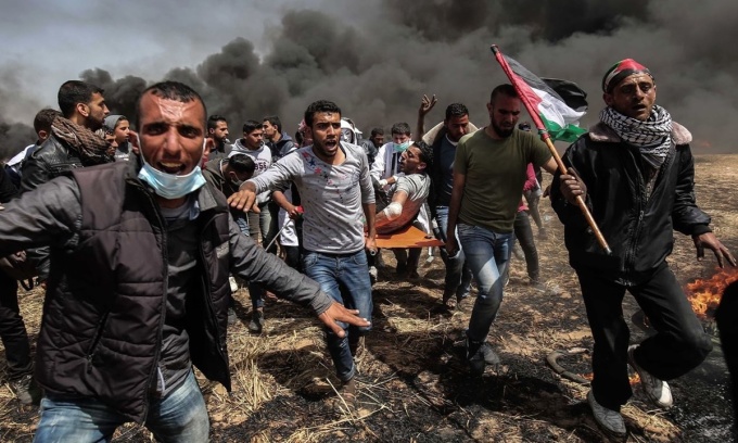 Một người biểu tình Palestine bị thương được những người khác khiêng trên cáng trong cuộc đụng độ với lực lượng an ninh Israel ở Gaza năm 2018. Ảnh: AFP