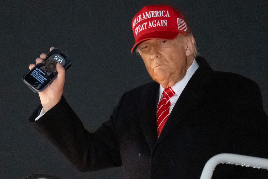 Tổng thống Mỹ Donald Trump bước xuống từ chuyên cơ, tay cầm điện thoại có ảnh nền màn hình khóa là chính ông, tại căn cứ không quân ở Maryland, ngày 30/5. Ảnh: AFP