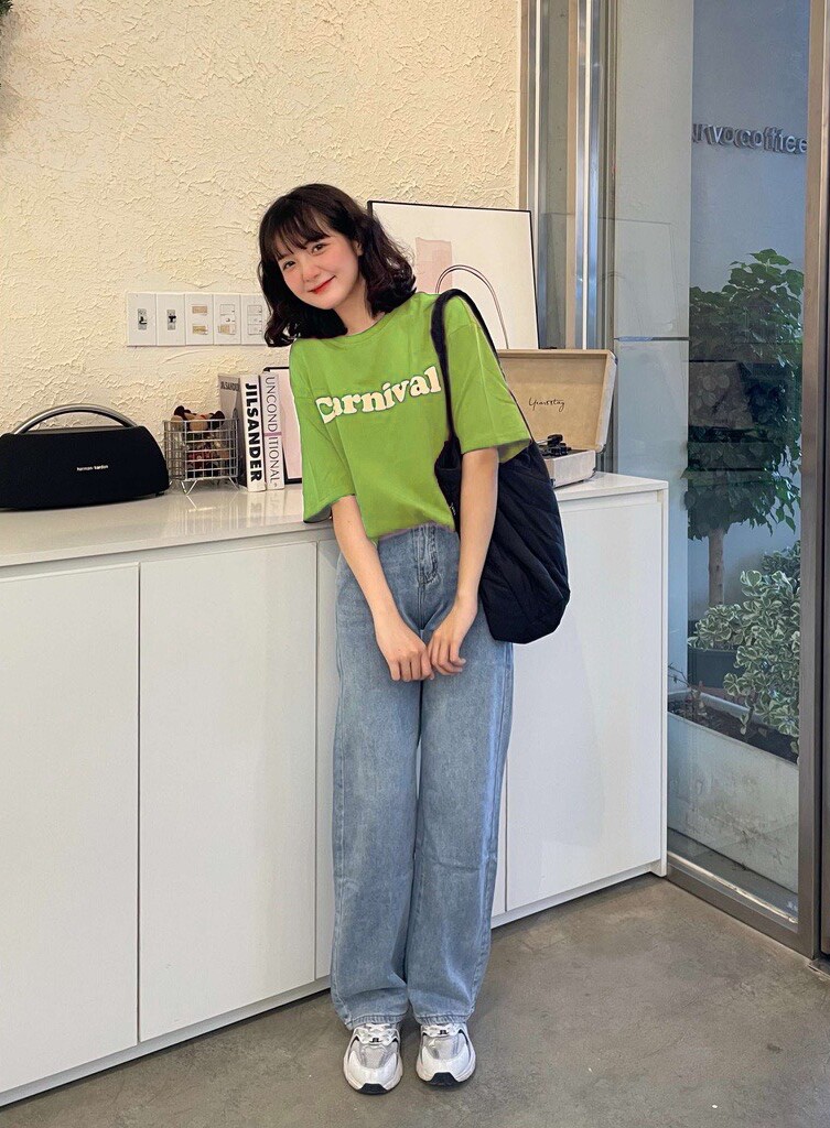 Phong cách retro trẻ trung với áo thun xanh neon in chữ nổi bật phối cùng quần jeans ống đứng.
