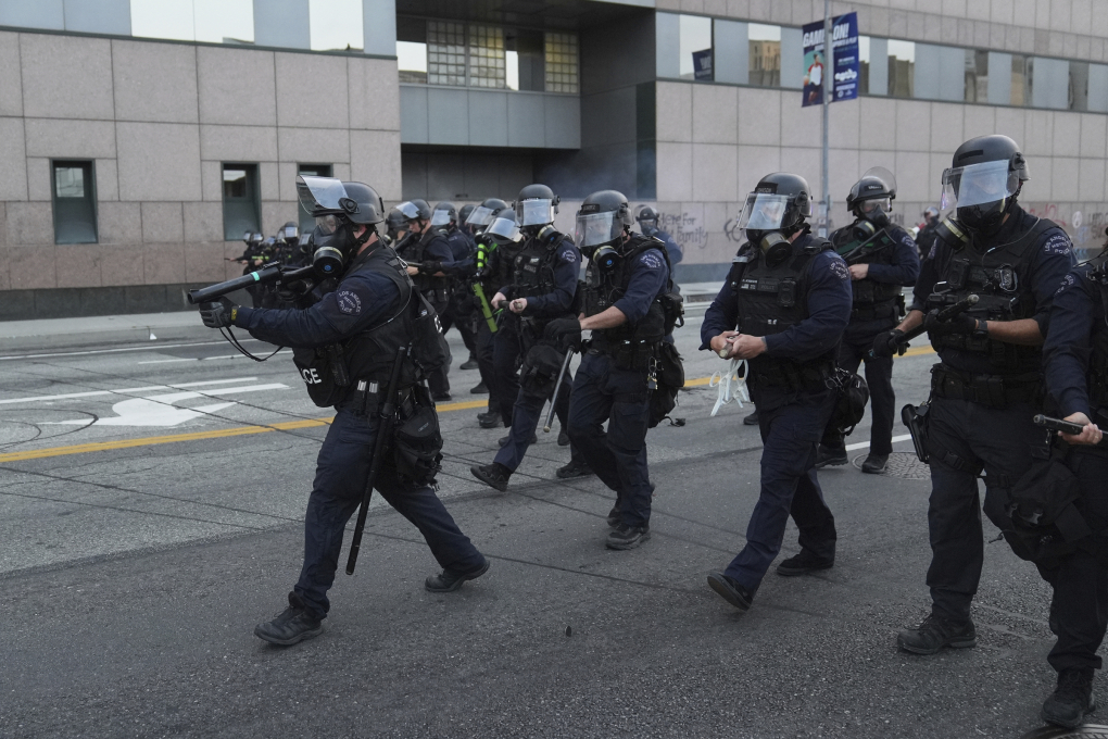 Lực lượng cảnh sát chống bạo động đi giải tán đám đông biểu tình ở Los Angeles, bang California ngày 6/6. Ảnh: AP