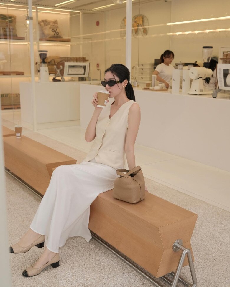 Hà Tăng phối áo phông cùng màu chân váy đen suông dài.