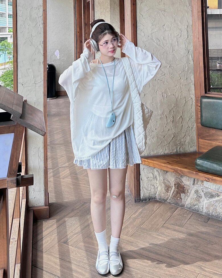 Áo dệt kim trắng mỏng phối với set đồ sáng màu như áo 2 dây trắng và quần short ống rộng mang đến diện mạo tươi sáng và tinh khôi.