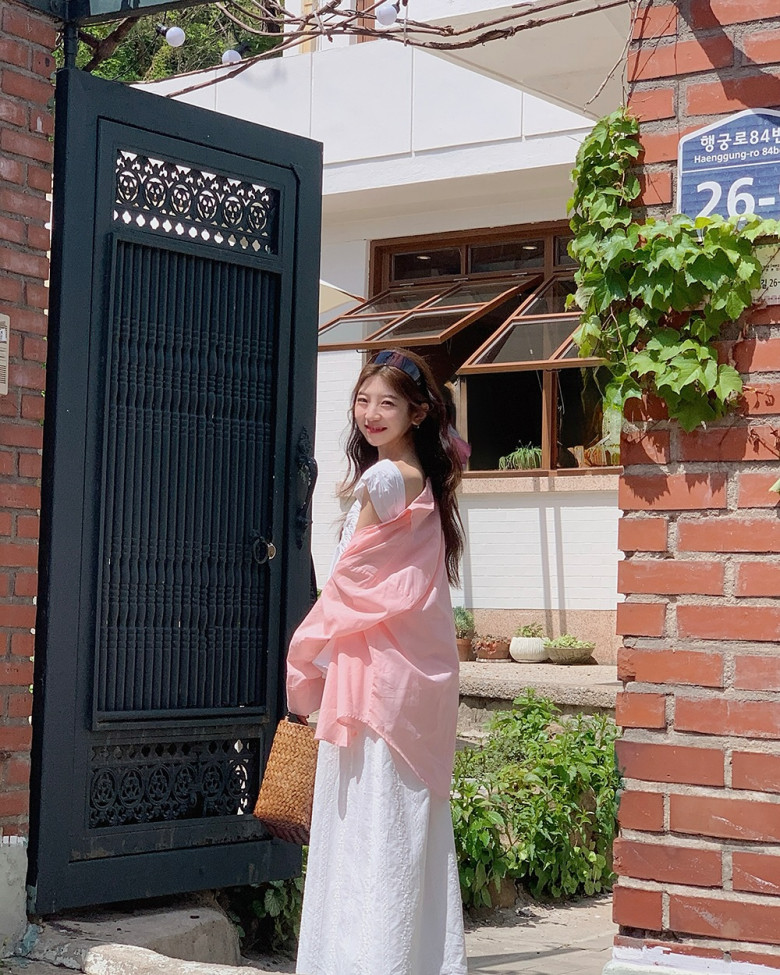 Vẻ ngoài thanh lịch pha chút thơ mộng với đầm trắng hai dây và sơ mi pastel hồng khoác hờ. Set đồ gợi cảm giác nhẹ tênh, phù hợp cho những buổi dạo chơi ngày hè đầy nắng. 