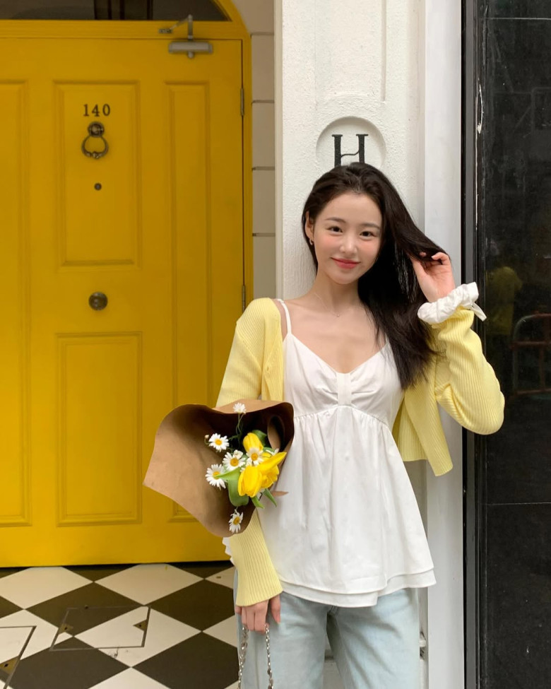 Áo cardigan vàng chanh phối với áo hai dây trắng tinh khôi, kết hợp quần jeans phom rộng nhẹ nhàng tạo nên tổng thể thanh lịch, tươi sáng và đầy sức sống cho ngày hè.