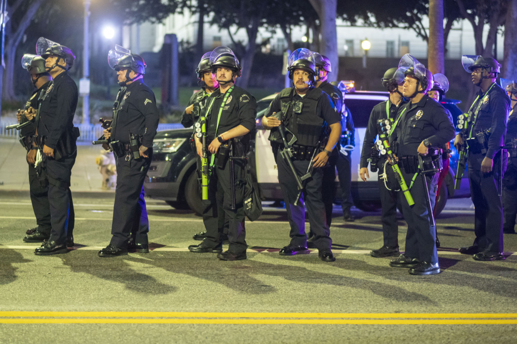 Cảnh sát Los Angeles trong trang phục chống bạo động tuần tra trên đường phố trung tâm khi lệnh giới nghiêm có hiệu lực đêm 10/6. Ảnh: AFP