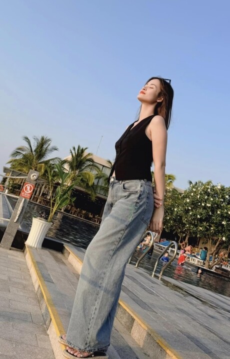 Đông Nhi tạo dáng với áo gile phối quần jeans ống rộng. Set đồ đơn giản mà thời thượng và tạo cảm giác thoải mái cho cô khi manh thai. 