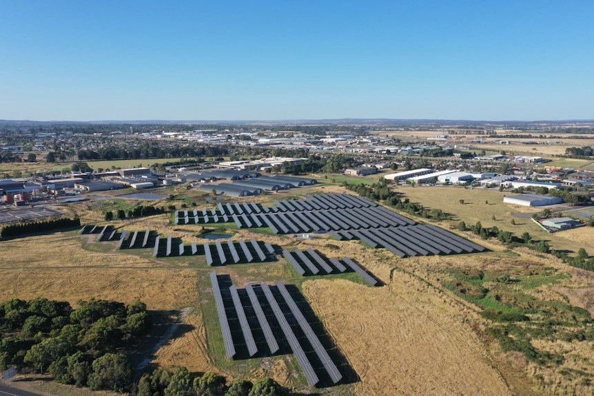 an aerial view of solar panels in open fields 