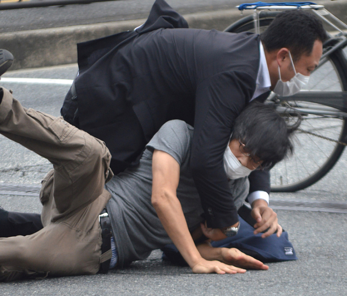 Cảnh sát khống chế nghi phạm Tetsuya Yamagami (áo xám) tại hiện trường. Ảnh: AFP.